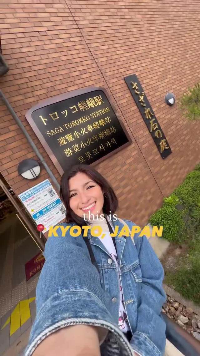 Selfie beneath a Japanese railway sign in Kyoto