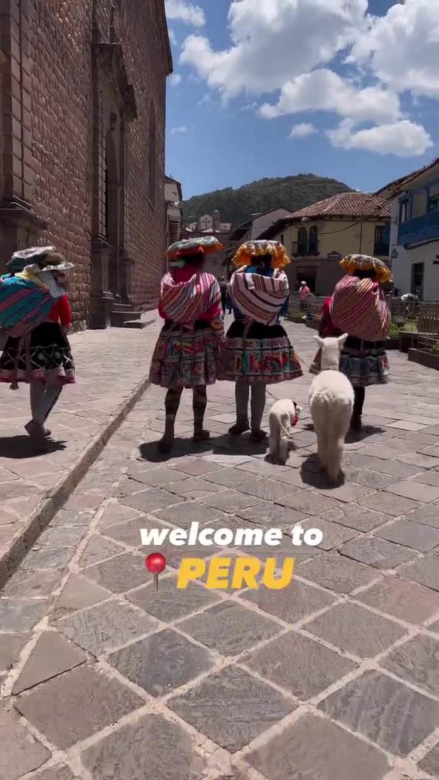 Women in traditional dress with an alpaca on a Cusco street